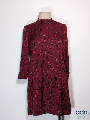 La robe est rouge et noire, avec des taches noires.