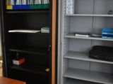 a room with a desk, shelves, and a bookcase