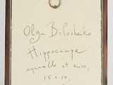 an old picture of a ring hanging on a wall with a note attached to it