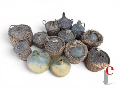a pile of wicker baskets and vases on a white surface