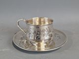 une tasse et une soucoupe en argent posées sur un plateau en argent