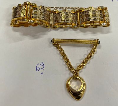 deux bracelets en or et une broche posés sur une table