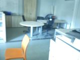 a blurry image of a kitchen with a table and a chair