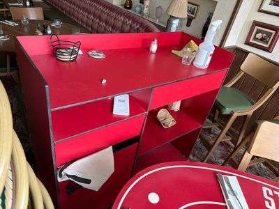une table rouge sur laquelle est posé un panneau, dans un restaurant