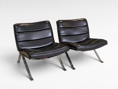 pair of black leather lounge chairs with chrome legs on a white background