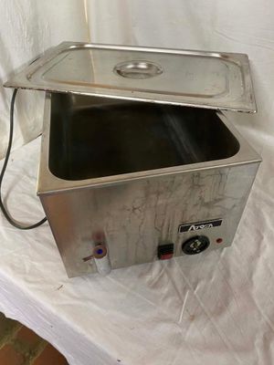 a small stainless steel container with a lid on a white sheet