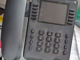 a black telephone sitting on top of a desk next to a keyboard