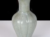 a white vase sitting on a table with a black background