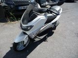 un scooter garé sur un parking à côté d'une voiture