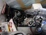 a pile of assorted electronics and other items in a box