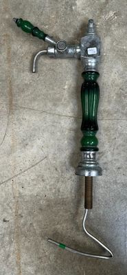 une poignée verte sur la poignée d'un robinet d'eau au sol