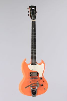 une guitare électrique orange accrochée à un mur blanc