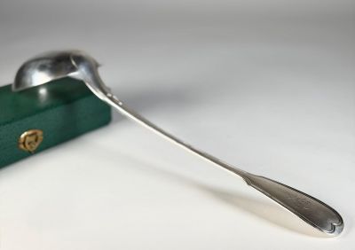 une cuillère en argent et une boîte verte posées sur une table