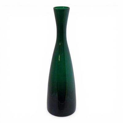 a green vase that is sitting on a white surface