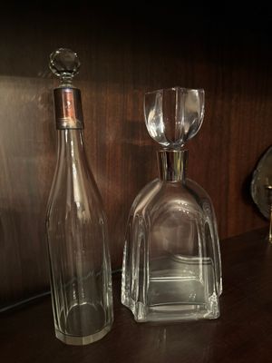 une bouteille et un verre posés sur une étagère à côté d'une horloge
