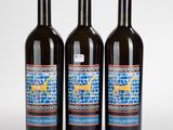 trois bouteilles de vin sont posées sur une surface blanche