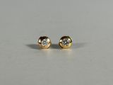 a pair of diamond stud earrings on a white surface