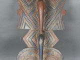 une image représentant une sculpture en bois sur laquelle un oiseau est perché sur la tête