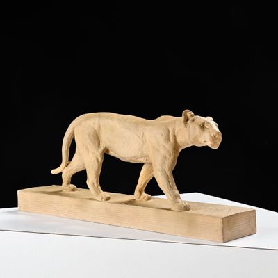 sculpture représentant un lion sur un bloc de bois, sur fond noir