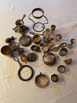 a pile of silverware on a table with a white table cloth
