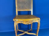 une vieille chaise en bois avec une assise en osier, sur fond bleu