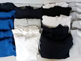many shirts laid out on a white surface