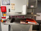 une cuisine équipée d'une cuisinière, d'un micro-ondes et d'autres ustensiles posés sur le plan de travail