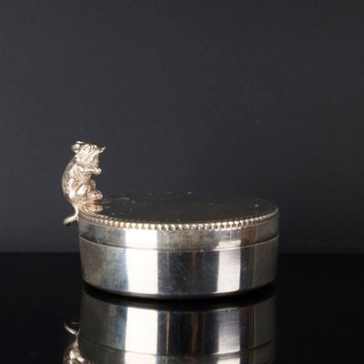 une assiette ancienne en argent, ornée d'un lion sur fond noir