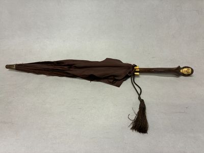 un parapluie marron orné d'un pompon
