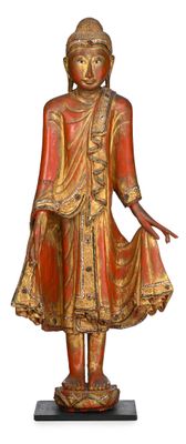 statue en bois représentant un Bouddha debout, posée sur un socle noir