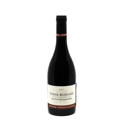 a bottle of red wine sitting on top of a white table
