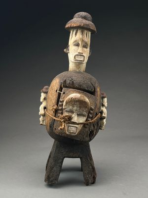 une image représentant une sculpture en bois d'un homme portant un enfant