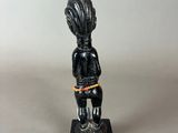 a small statue of a woman with a hat on her head