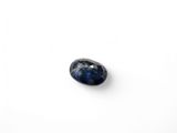 a close up of a blue sapphire stone on a white surface