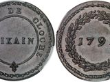 a silver coin with a wreath on the front and the back of it