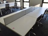 a room with a desk, chairs, and a television in it