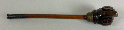 a pipe with a wooden handle on a white surface