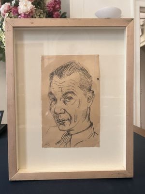 drawing of a man with a mustache in a frame on a table