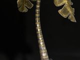 a metal sculpture of a palm tree on a black background