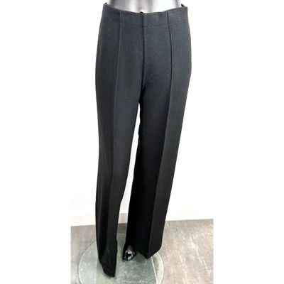 Le mannequin porte un costume noir et une cravate.