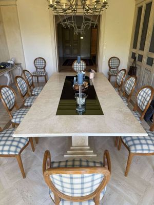 a table and chairs in a room with a chandelier in the background