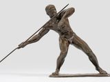 bronze statue of a man holding a spear and a stick