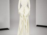 le dos d'une robe blanche ornée d'un nœud, sur un mannequin, un mannequin, un mannequin, un mannequin, un mannequin, un mannequin, un mannequin