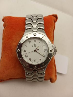 une photo d'une montre-bracelet posée sur un coussin orange