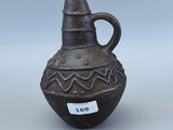 un petit vase marron muni d'une étiquette