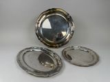 two silver plated dishes and a mirror on a white surface