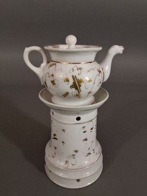 une théière blanche posée sur une pile d'assiettes