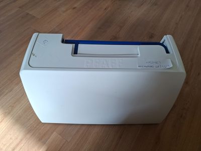 a white box with a blue handle sitting on a wooden floor