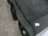a roll of black fabric on the floor next to a box