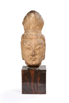 une image représentant une statue d'une tête posée sur un socle en bois